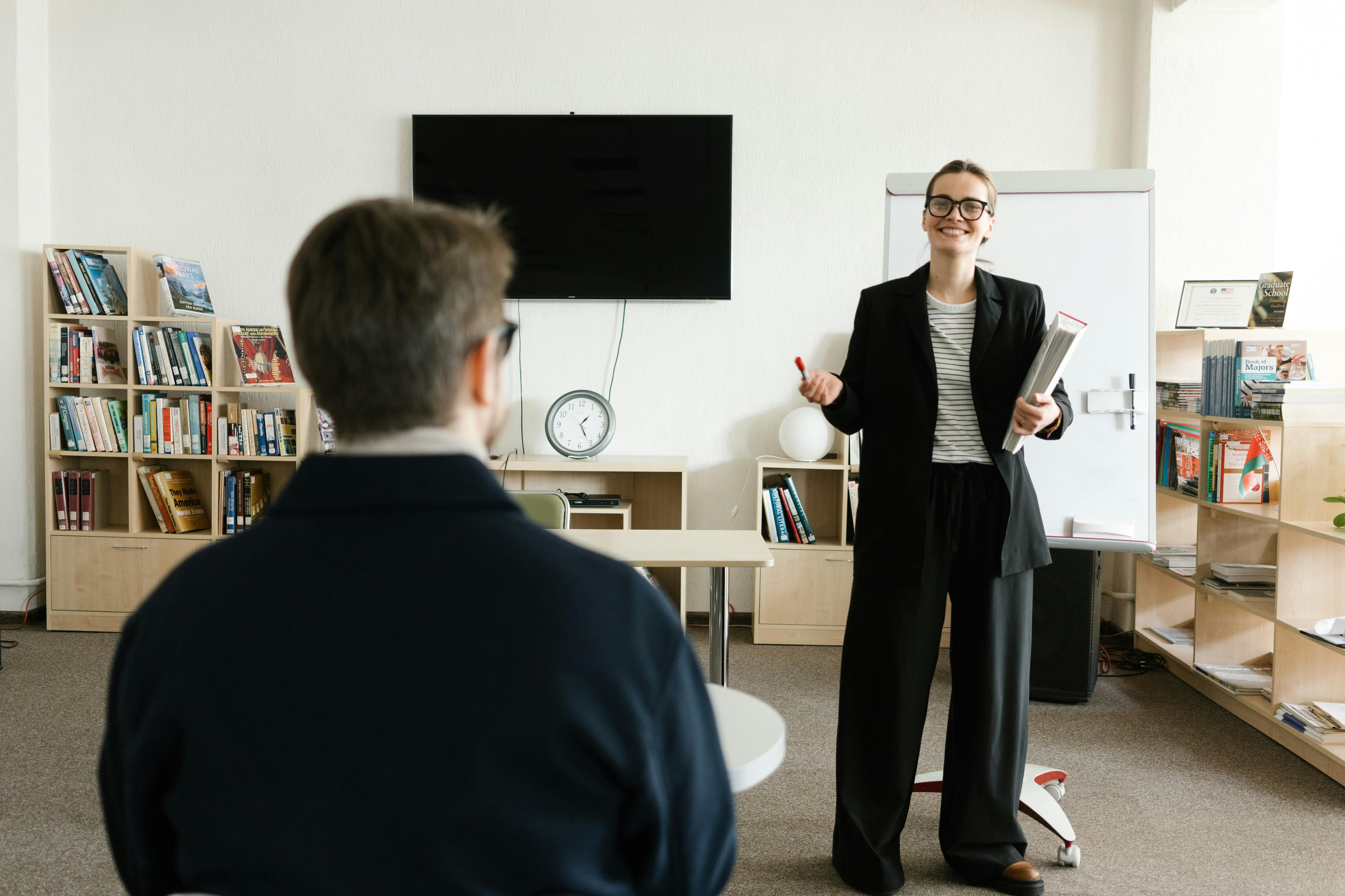 woman smiling while explaining something to an employee in an office 