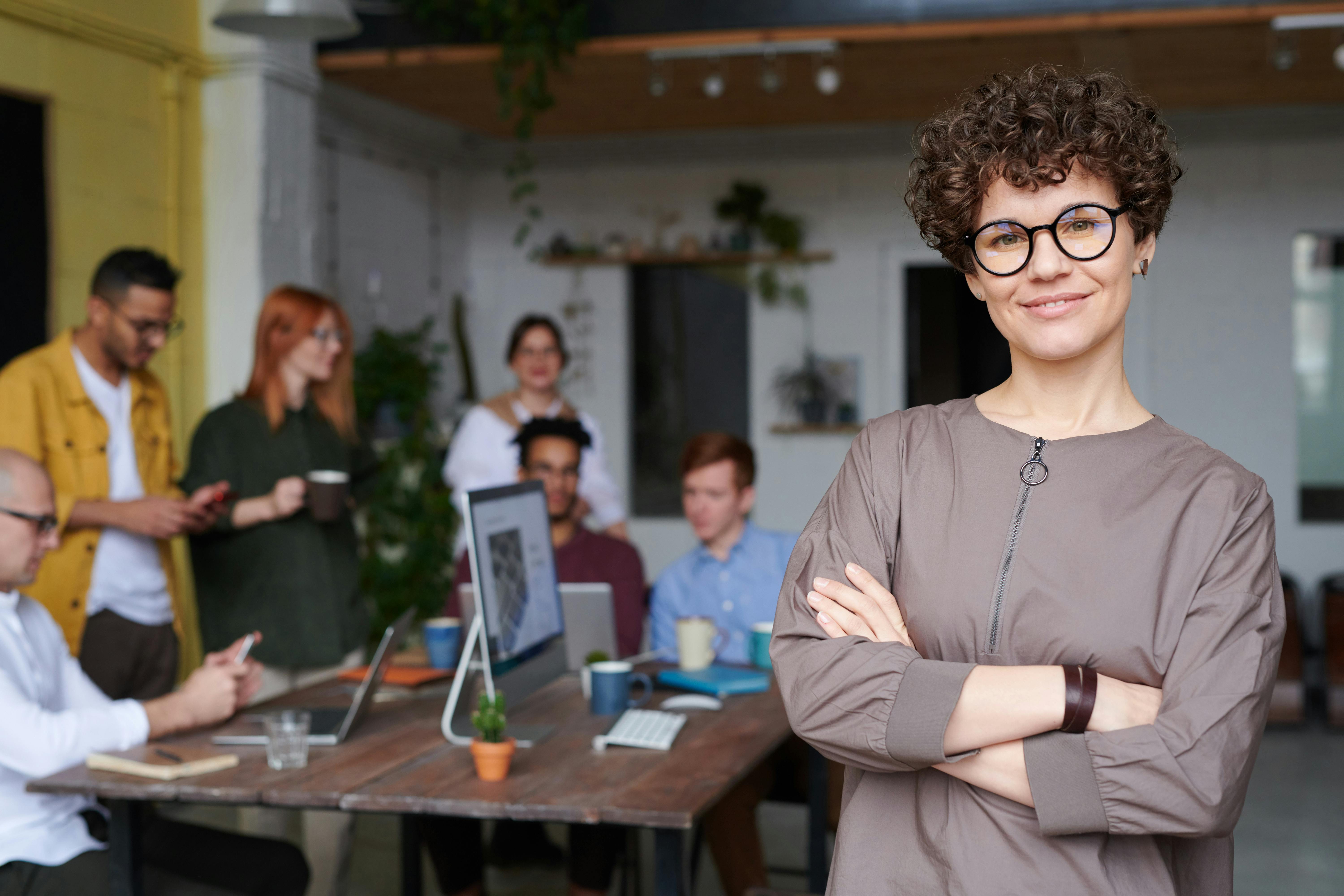 Woman standing in front of a team of employees working together at a conference table